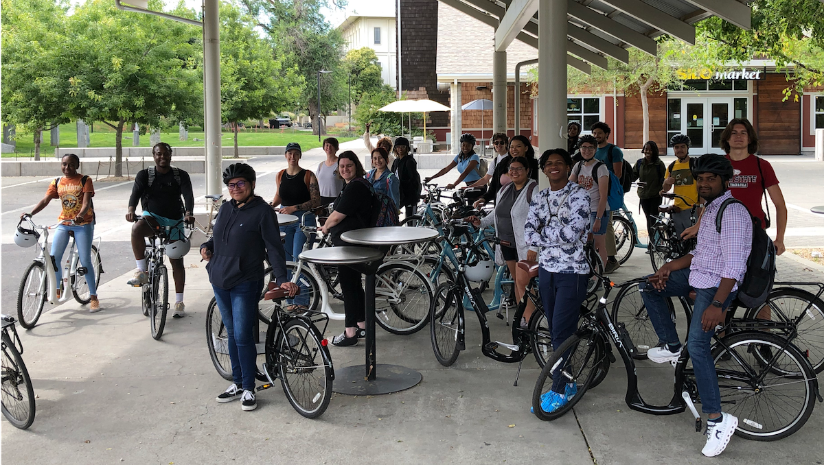 people standing next to bikes