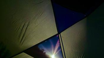 full moon seen through a tent